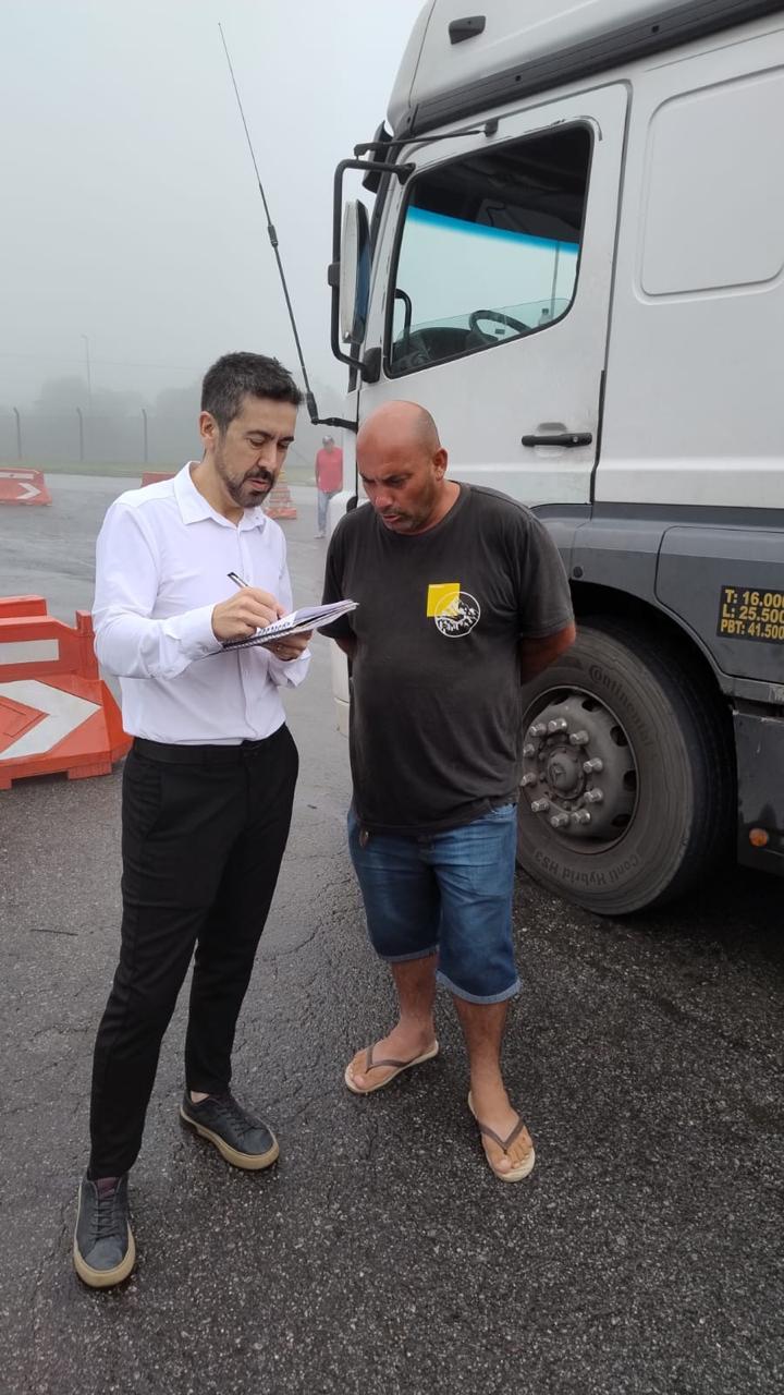 Dr. Marcelo Rua anotando informações de caminhoneiro